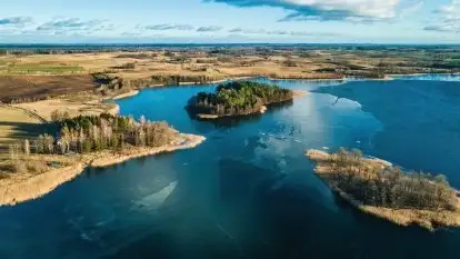 Zimowa sceneria nad plażą przy jeziorze Szóstak